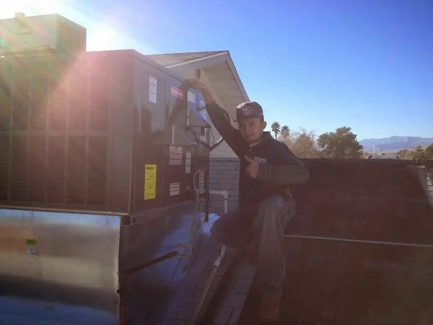 HVAC technician performing Air Duct Cleaning on a rooftop unit in Liberty Triangle
